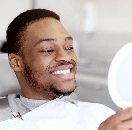 A man looking at his teeth in a mirror